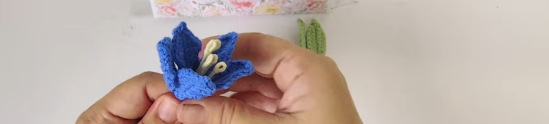 Assembling five crochet hibiscus petals around five yellow flower centers