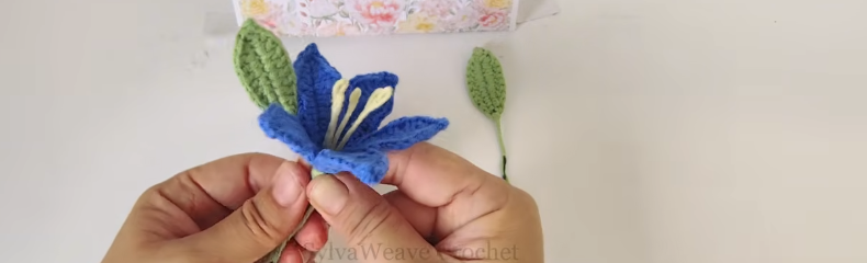 Attaching green leaves below the crochet hibiscus flower