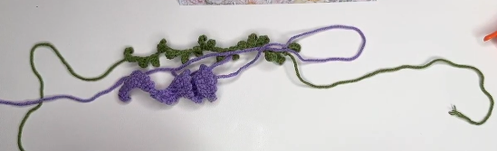 Purple crochet lavender flower and green leafy stem ready for assembly