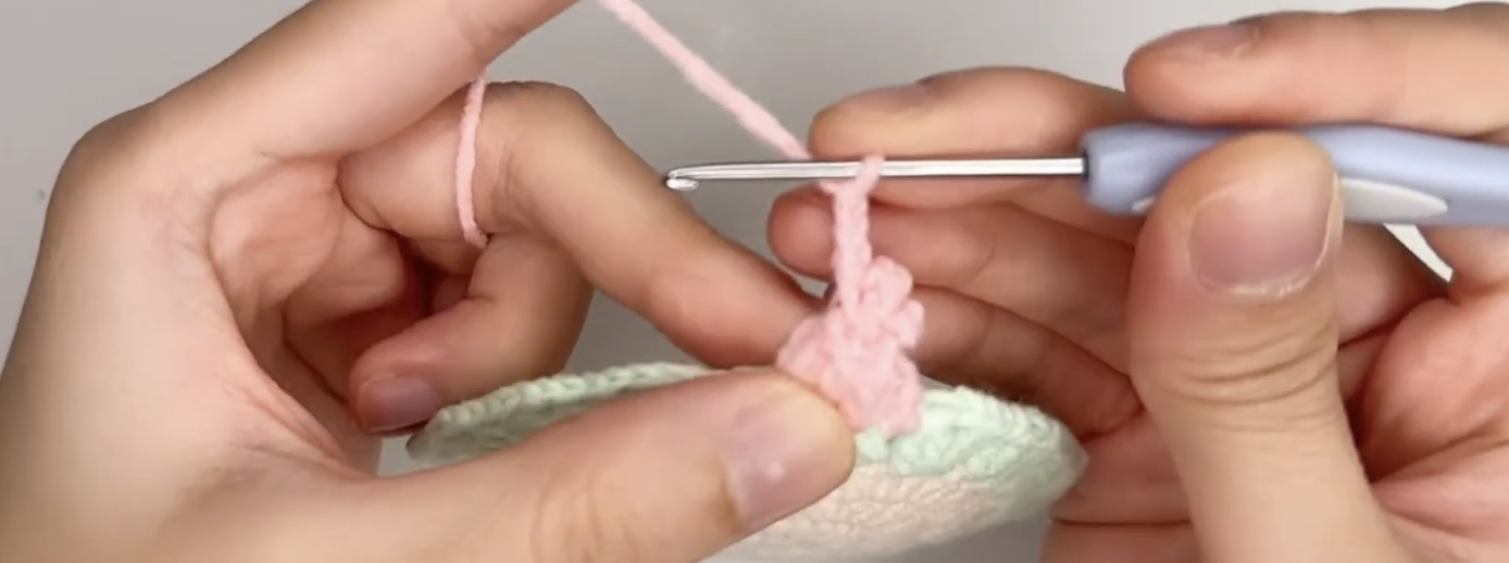 Crocheting leaf clusters between the tulip flowers