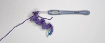 Crochet lavender flower worked in purple yarn with picot stitches