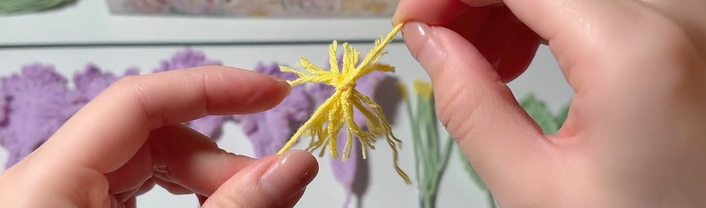 Tying and cutting the yellow yarn flower centre